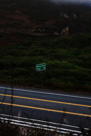 A vertical shot of a highway surrounded by trees and cliffsの写真素材