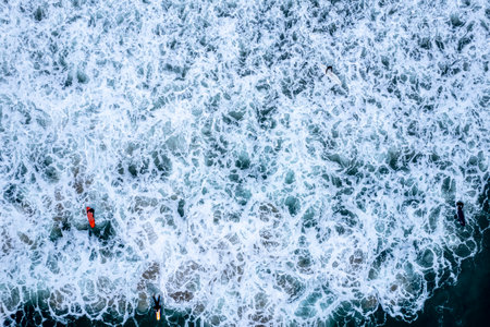 An aerial view of surfers riding the waves in Newport Beach, Californiaの写真素材