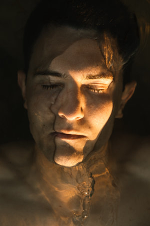 A vertical closeup of a Caucasian man in the water during a sunset