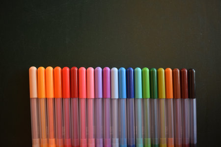 A closeup of the set of colored pens on dark background.