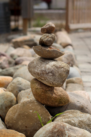 A vertical shot of a stack of stones in a park