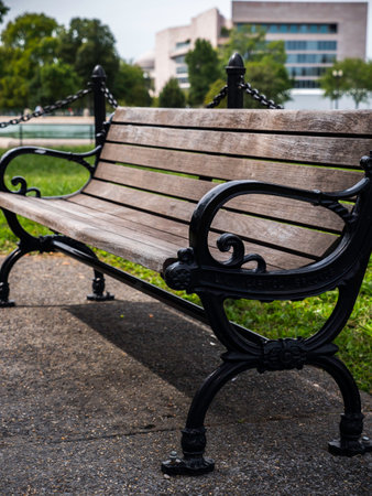 A vertical shot of an old wooden bench in a park