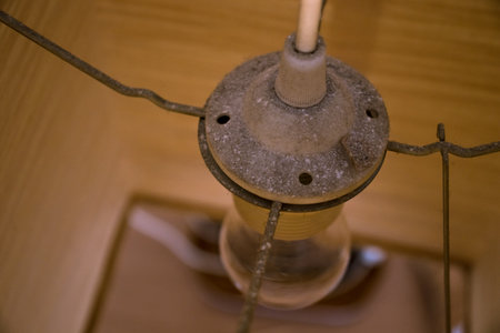 Close up shot of a light bulb and a holder in a lampshade.