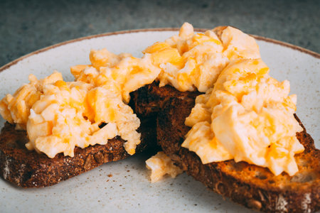 A closeup shot of a gourmet scrambled egg sandwich on a plateの写真素材