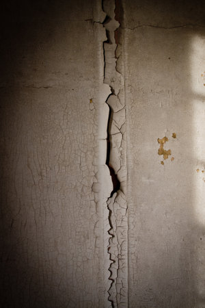 A vertical shot of an old wall with cracked paint in an abandoned buildingの写真素材