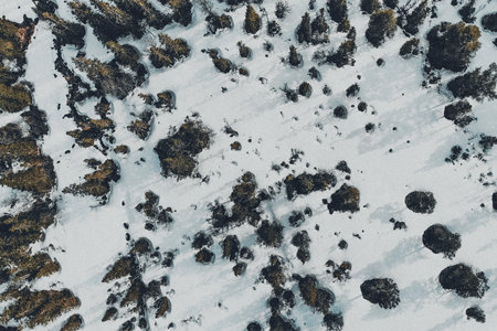 An aerial view of a beautiful snow-covered landscape with rock formations
