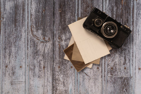 35 mm vintage camara  on eroded wood background with some old pictures