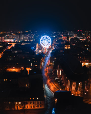 A vertical shot of the Paris Ferris wheel surrounded by lights at night in France
