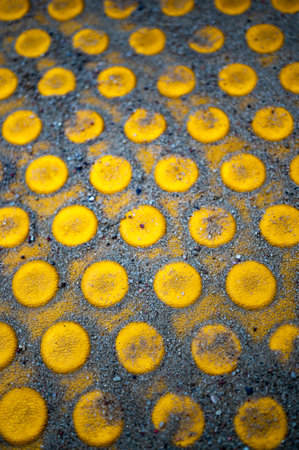 A vertical closeup of yellow circle shapes covered in sand