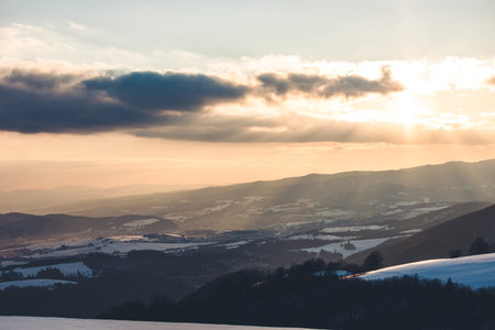An orange scene of the snowy Kozi chrbat mountain in Low Tatras National Park in Slovakia at sunsetの写真素材
