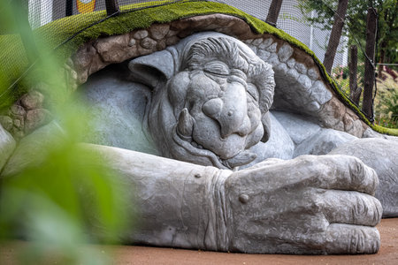 A closeup shot of a sleeping beast statue in a gardenの写真素材
