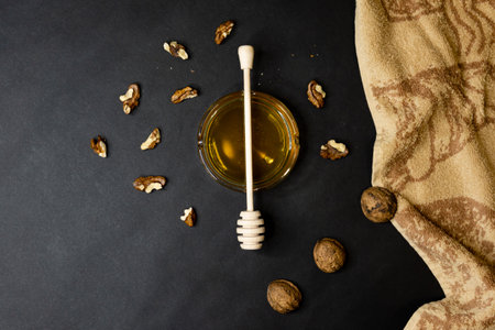 A top view of honey and walnuts on a black backgroundの写真素材