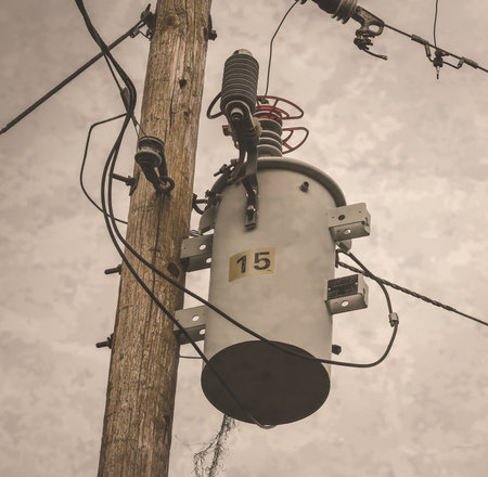 A low angle shot of a power transformer on a wooden poleの写真素材
