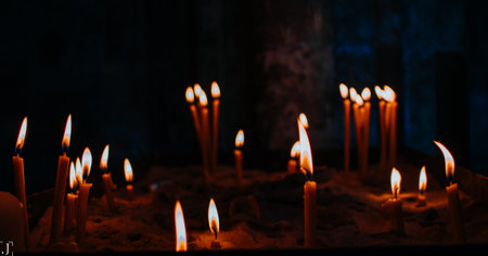 A closeup shot of candles in the church on dark backgroundの写真素材