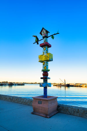 A vertical shot of a colorful birdhouse near a sea in the United Statesの写真素材