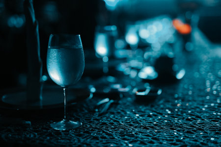 A closeup of glasses of cold drinks on the dinner table with a dark blurry background