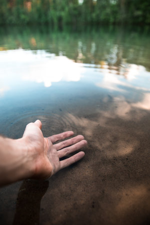 A close-up shot of a person wrapping his hand in a lake