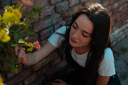A closeup shot of a young female posing near flowers