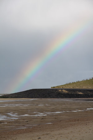 A beautiful view of a beach and a Rainbow in the sky in Vlissingen, The Netherlandsの写真素材