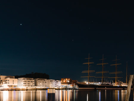 A scenic view of a city port with residential buildings in the background at nightの写真素材
