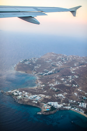 An aerial view of a coastal town and blue ocean water as seen from an airplaneの写真素材