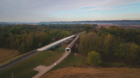 An autumn landscape with a bridge over the creek in the forest