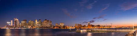 A panoramic shot of the cityscape of  Boston at sunset