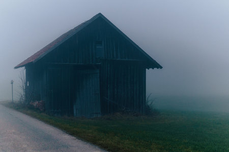 A view of an abandoned house in Allgovia on a foggy dayの写真素材