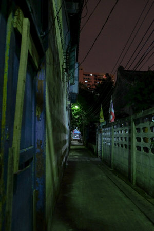 A dark alley with walls and Thai Flags in Talad Noi, Bangkok, Thailand.の写真素材