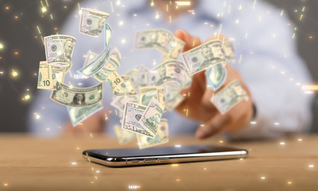 A businessman tapping on a floating render of dollar bills over a phone screenの写真素材