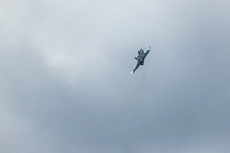A low angle shot of a plane flying in the cloudy skies