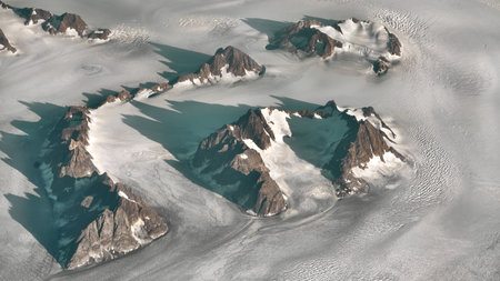 A magnificent aerial shot of high, foggy mountains partly covered in snow and iceの写真素材