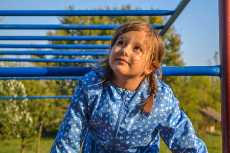 A shallow focus shot of a little Serbian Caucasian girl in braided pigtails in a parkの写真素材