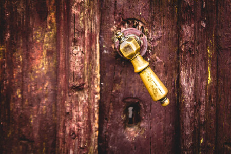 A closeup of an old and rustic knob on a wooden doorの写真素材