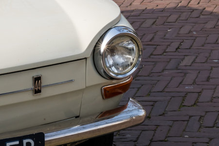 A closeup shot of the headlight of a vintage family car