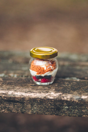 A vertical shot of a pudding with whipped cream and strawberries on a wooden table