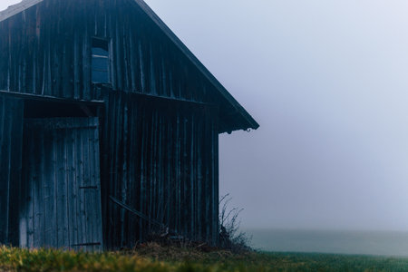 A view of an abandoned house in Allgovia on a foggy dayの写真素材