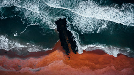 An aerial shot of a beach surrounded by the sea in the daylight - perfect for wallpapers