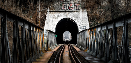 A scenic shot of a train railroad and a dark tunnelの写真素材