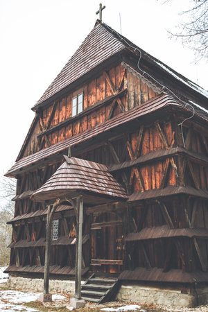 A vertical shot of a wooden church in Hronsek, Slovakia in winterの写真素材