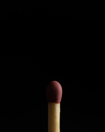 A closeup shot of an unburnt match on a black backgroundの写真素材