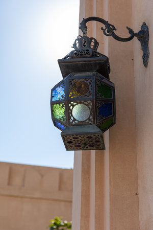 A closeup of an old Lewondr Hanging Lamp Bracket on the wall against a blue sky in Doha, Qatarの写真素材