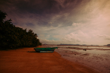 A beautiful shot of a boat near a sea under the cloudy skies in Ao Chalong, Phuket, Thailand