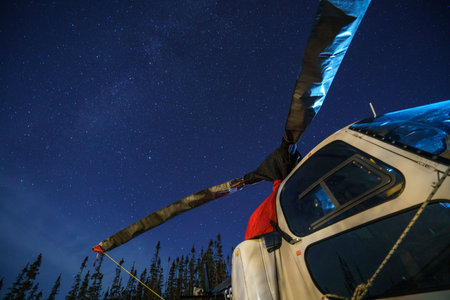 A helicopter in a forest under a starry night sky