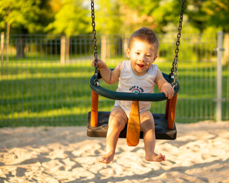A Child on a swing set in a playground in the Polandの写真素材