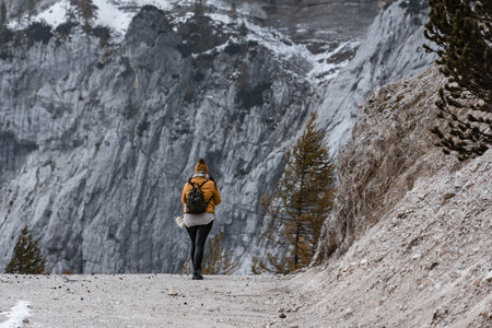 A beautiful view of a female hiker walking on the path under a magnificent mountain in Croatia