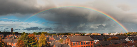 An aerial shot of a town under the cloudy skies and the rainbownの写真素材