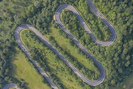 An aerial shot of a serpent road in the forest in Polandの写真素材