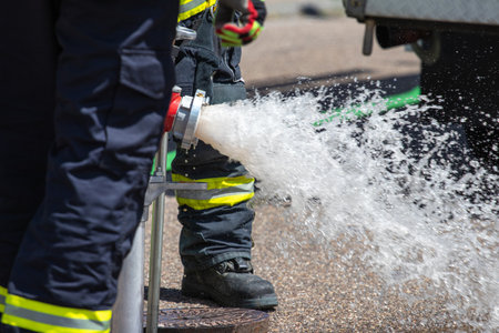 A closeup of German firefighters hard at work during daylightの写真素材