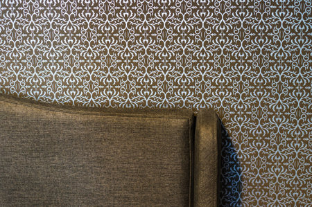 A closeup of a chair near the wall with a beautiful pattern